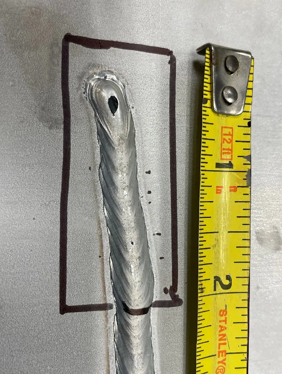 The ASTM G48 test coupon: marked test area on the GMAW weld bead with the large silica island at the crater where the bead terminates