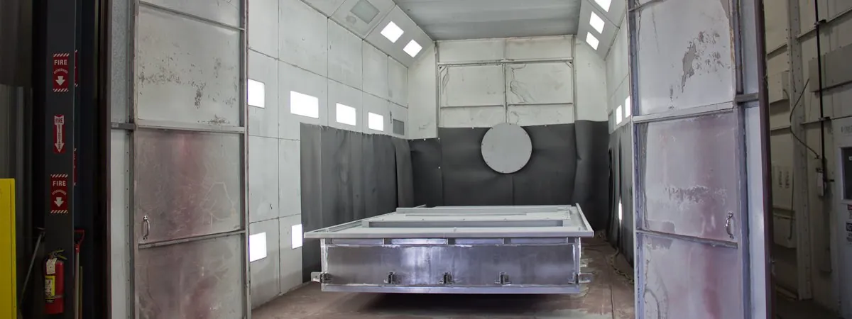 Large stainless steel assembly staged inside the bead blast room at Northern Manufacturing