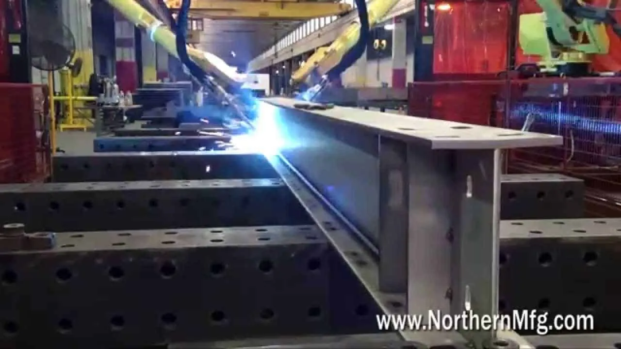 Twin robotic welding arms running simultaneous passes on a long stainless steel beam at Northern Manufacturing