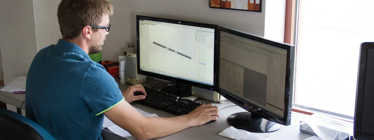 Northern Manufacturing engineer working in SolidWorks at a dual-monitor CAD workstation
