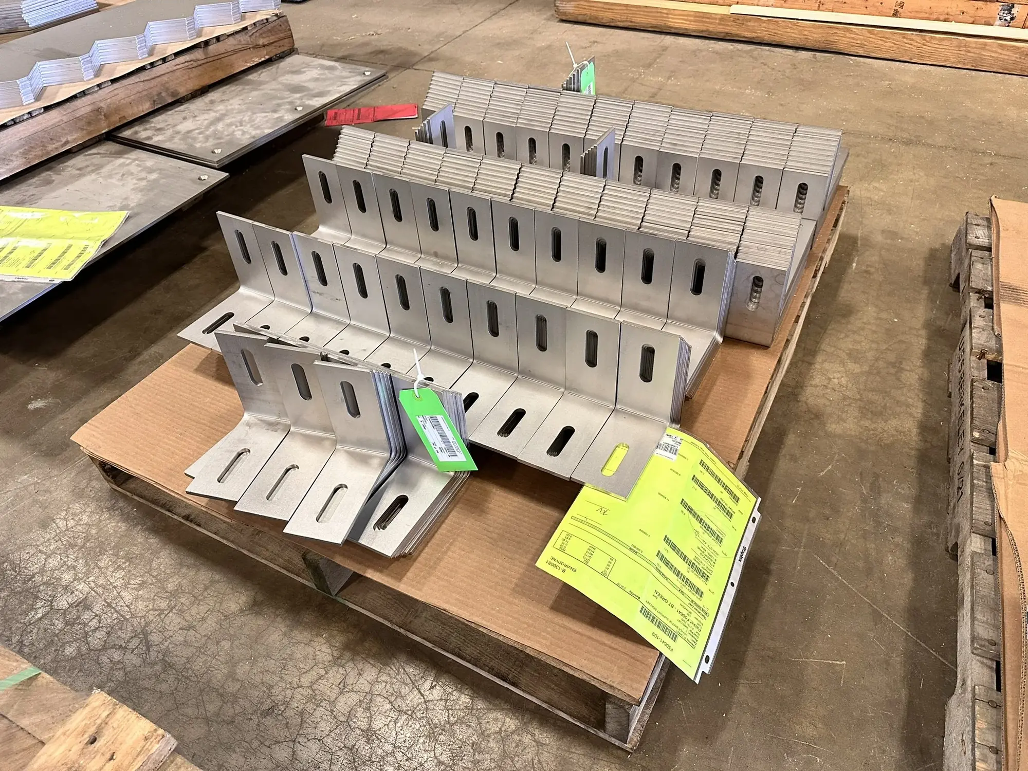 Row of 309S stainless steel furnace nozzle assemblies on a fixture table in the fabrication bay