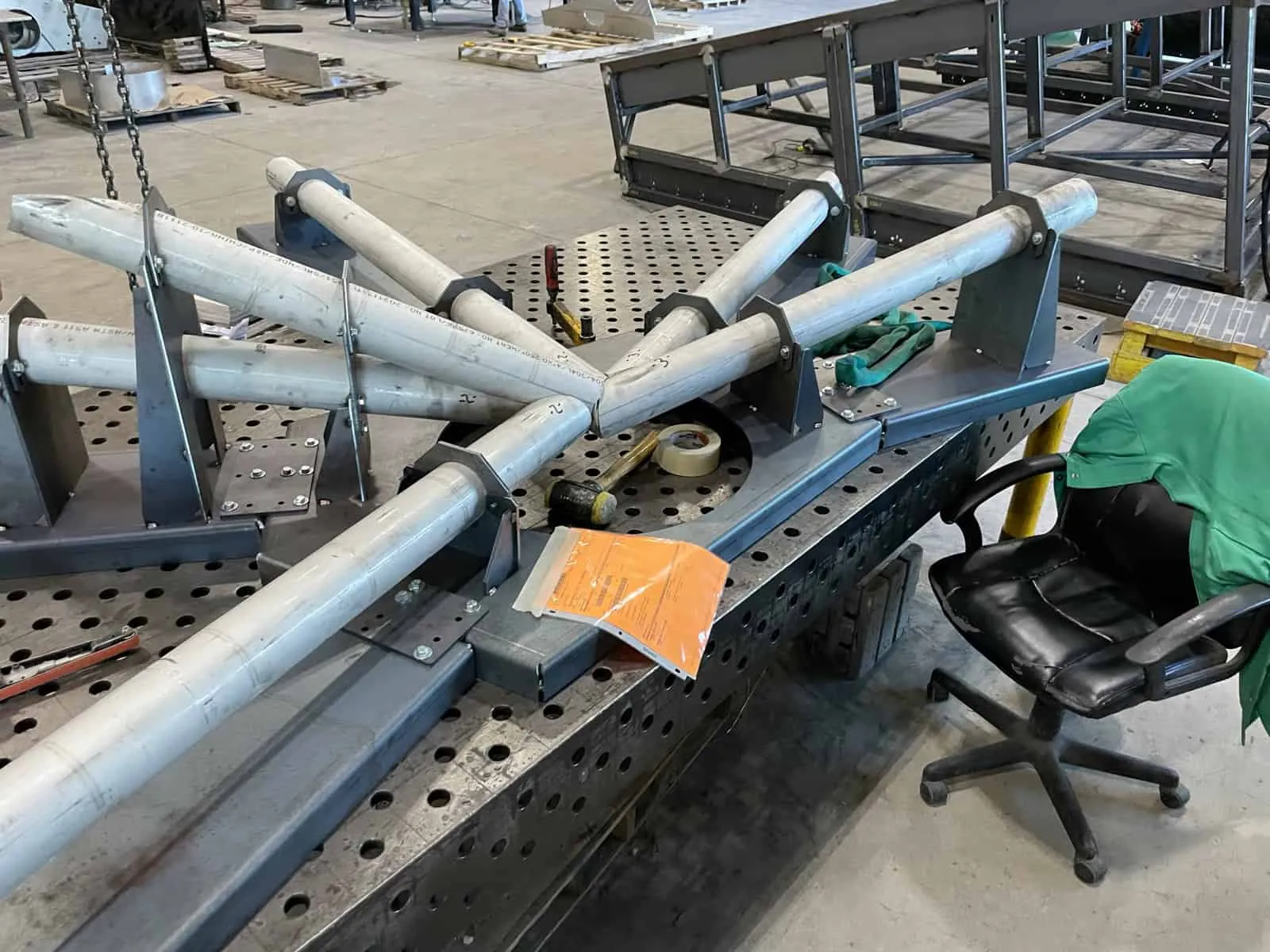 Curved stainless steel forming tooling and ring fixture on a work table