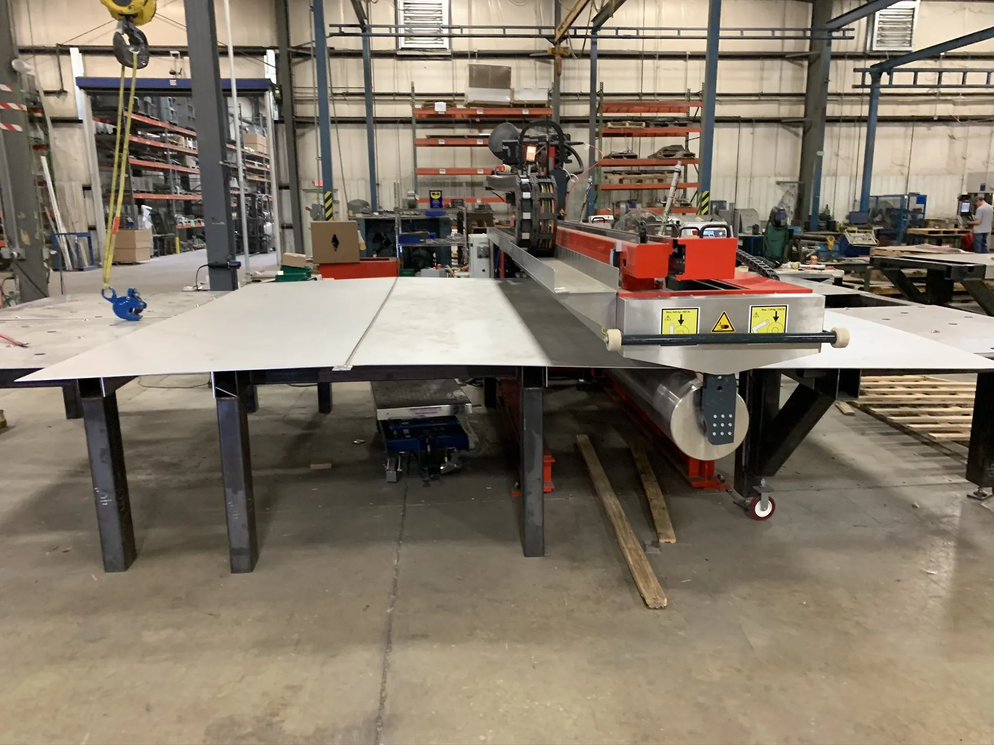 Sheet metal staged on a longitudinal seam welder table at Northern Manufacturing