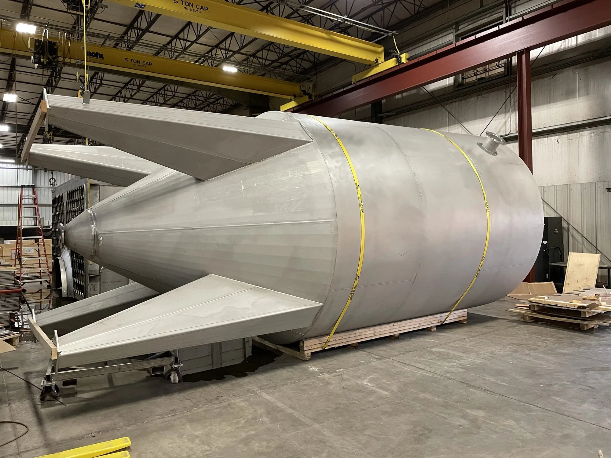 Rolled stainless steel cone segment test-stand assembly staged in the Northern Manufacturing fabrication bay