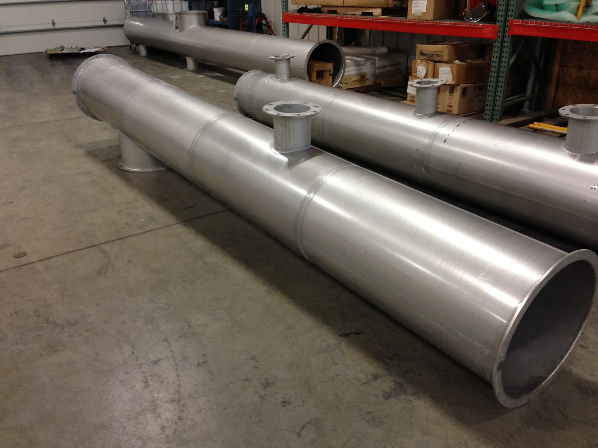 Large-diameter stainless steel pipe spools with flanged branch nozzles staged on the Northern Manufacturing shop floor