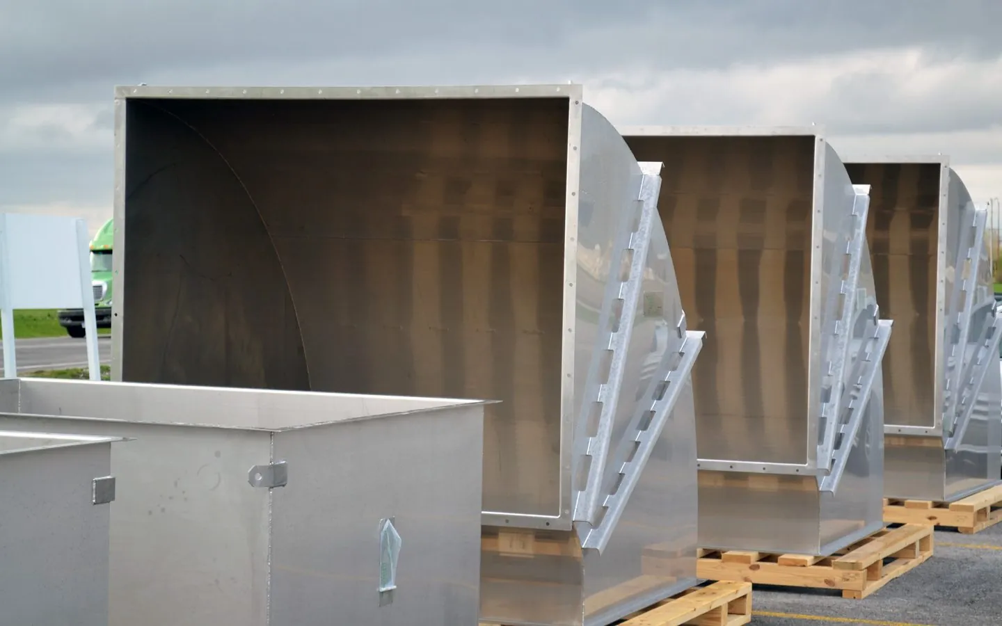 Large stainless steel duct elbows staged outdoors for shipment