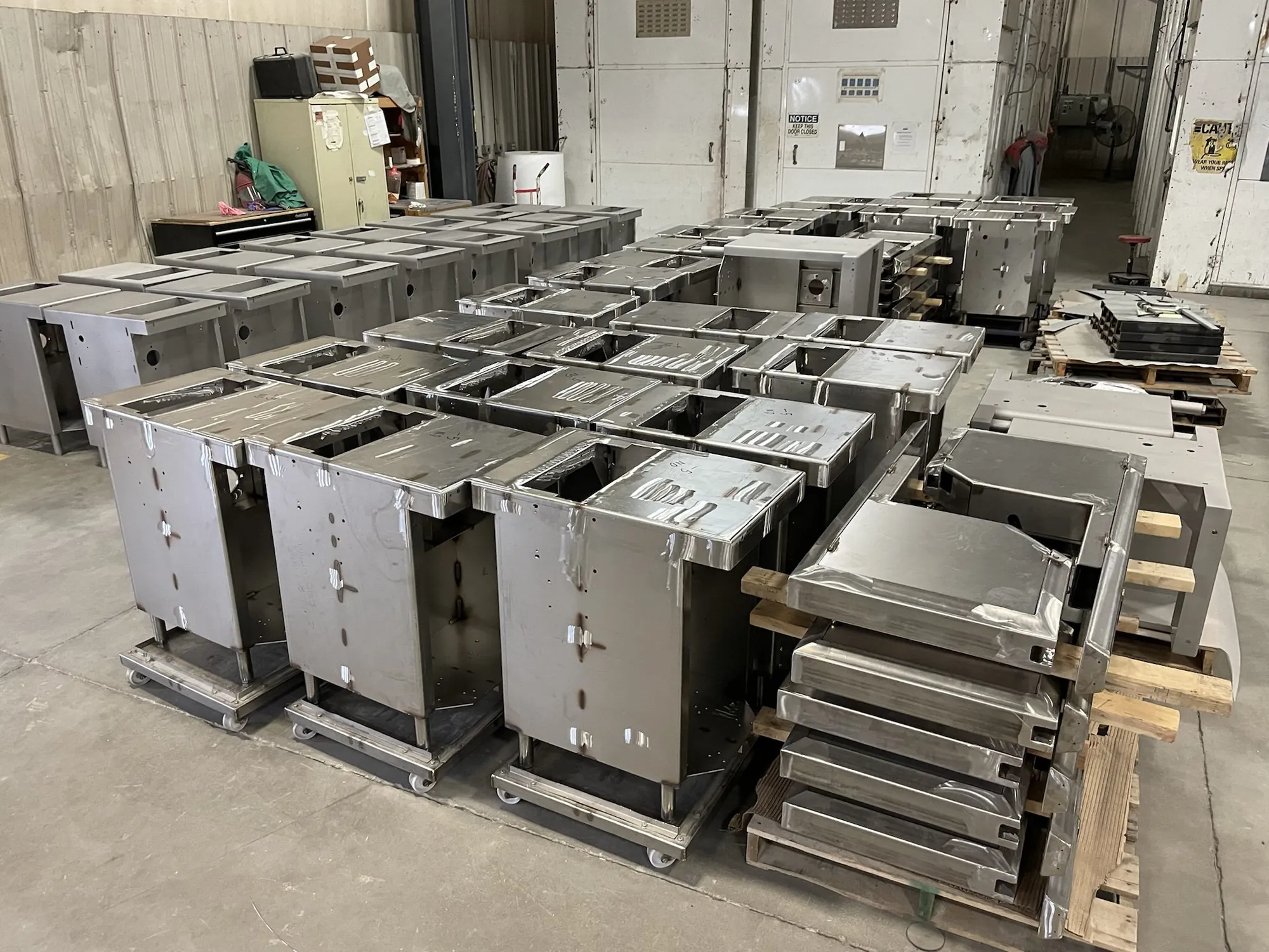 Rows of fabricated stainless steel equipment bases and enclosures staged in the Northern Manufacturing shop