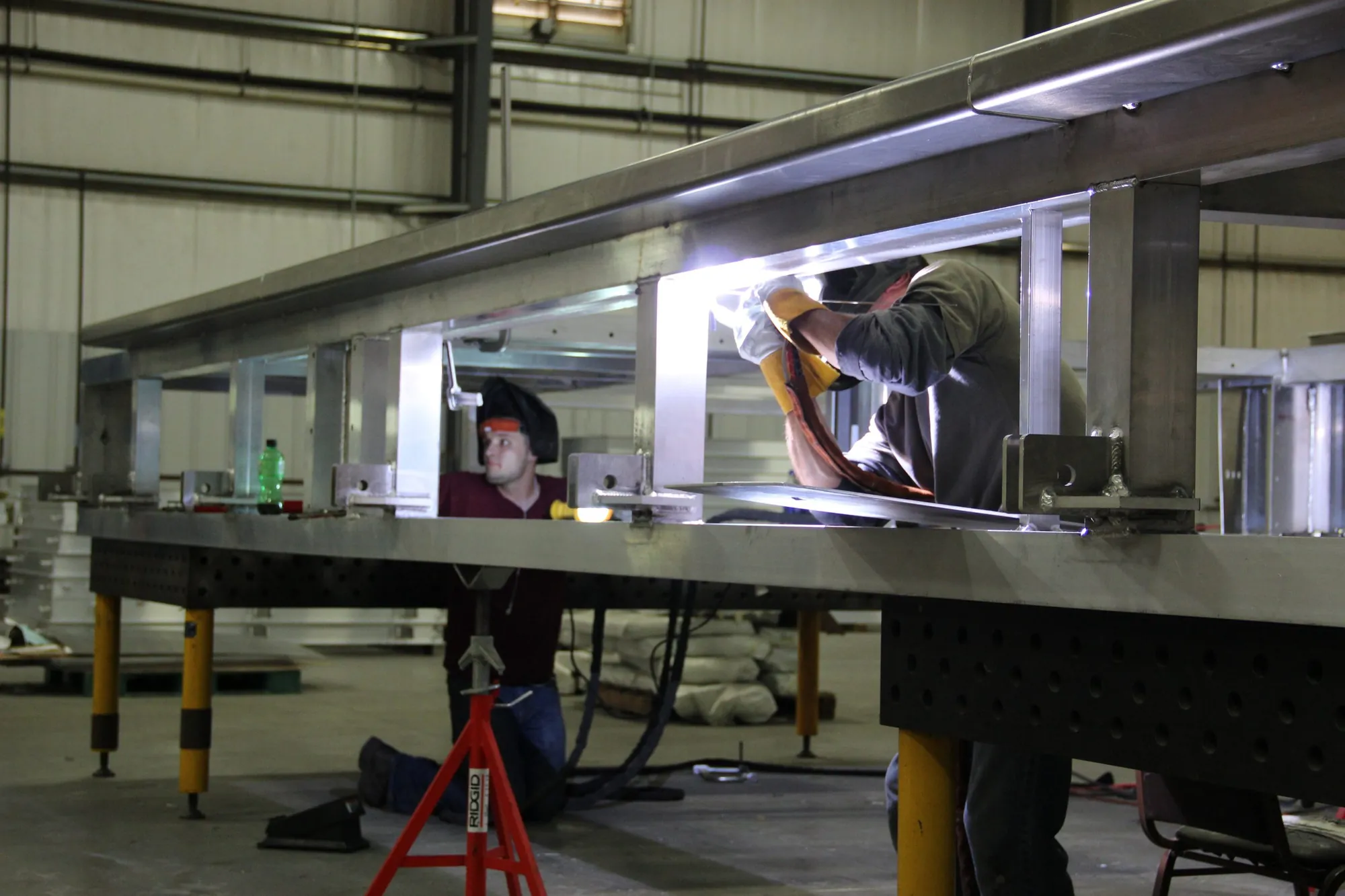 Two Northern Manufacturing welders running TIG passes inside a large structural beam assembly