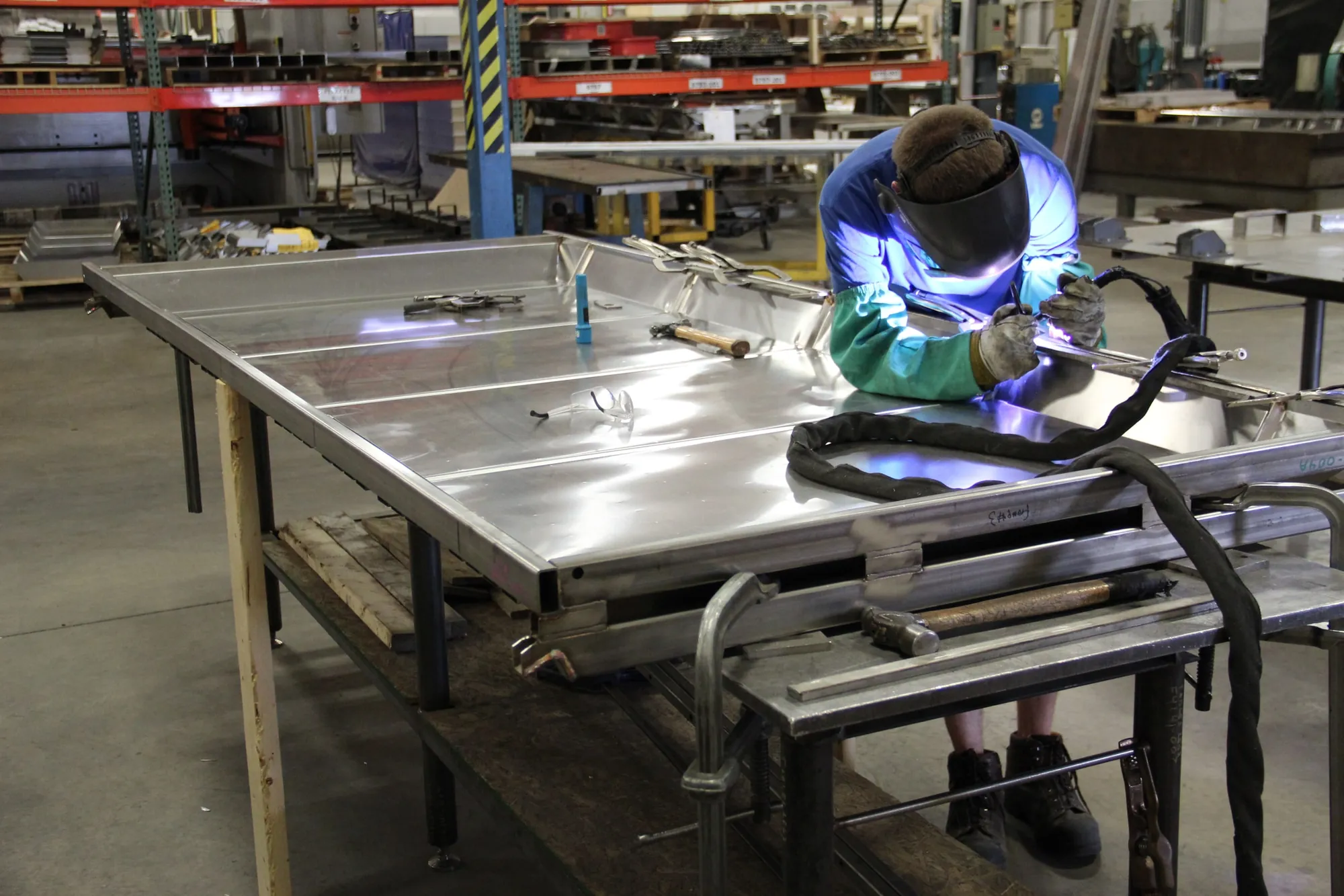 Welder running a manual GTAW pass on a stainless steel assembly at Northern Manufacturing