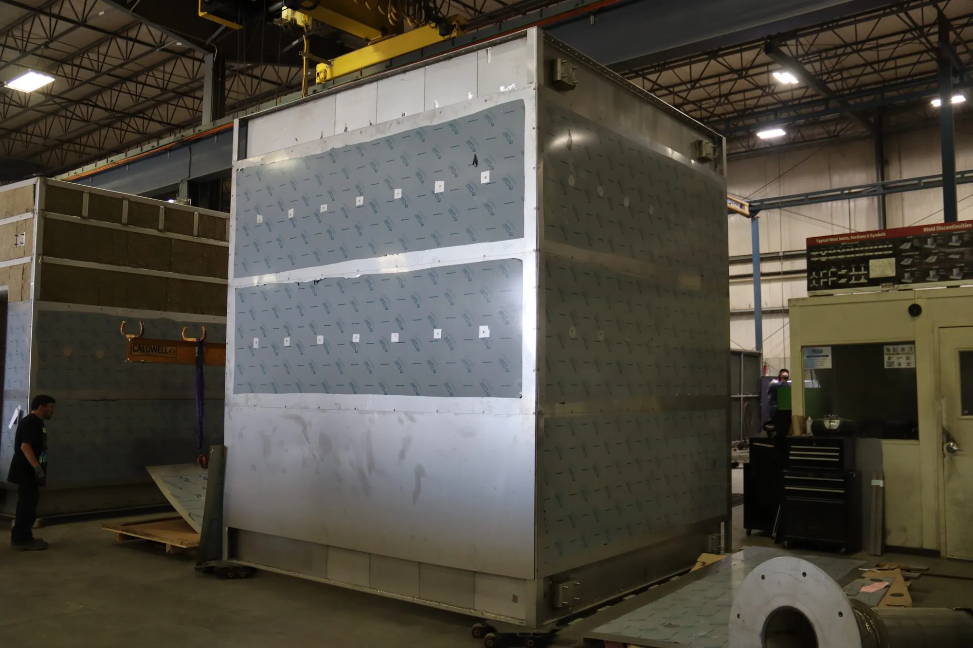 Large stainless steel housing with protective film in the fabrication bay