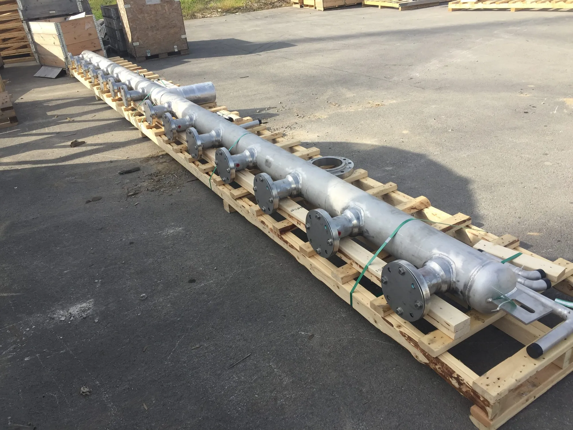 Long stainless steel distribution header with flanged branch nozzles palletized for shipment