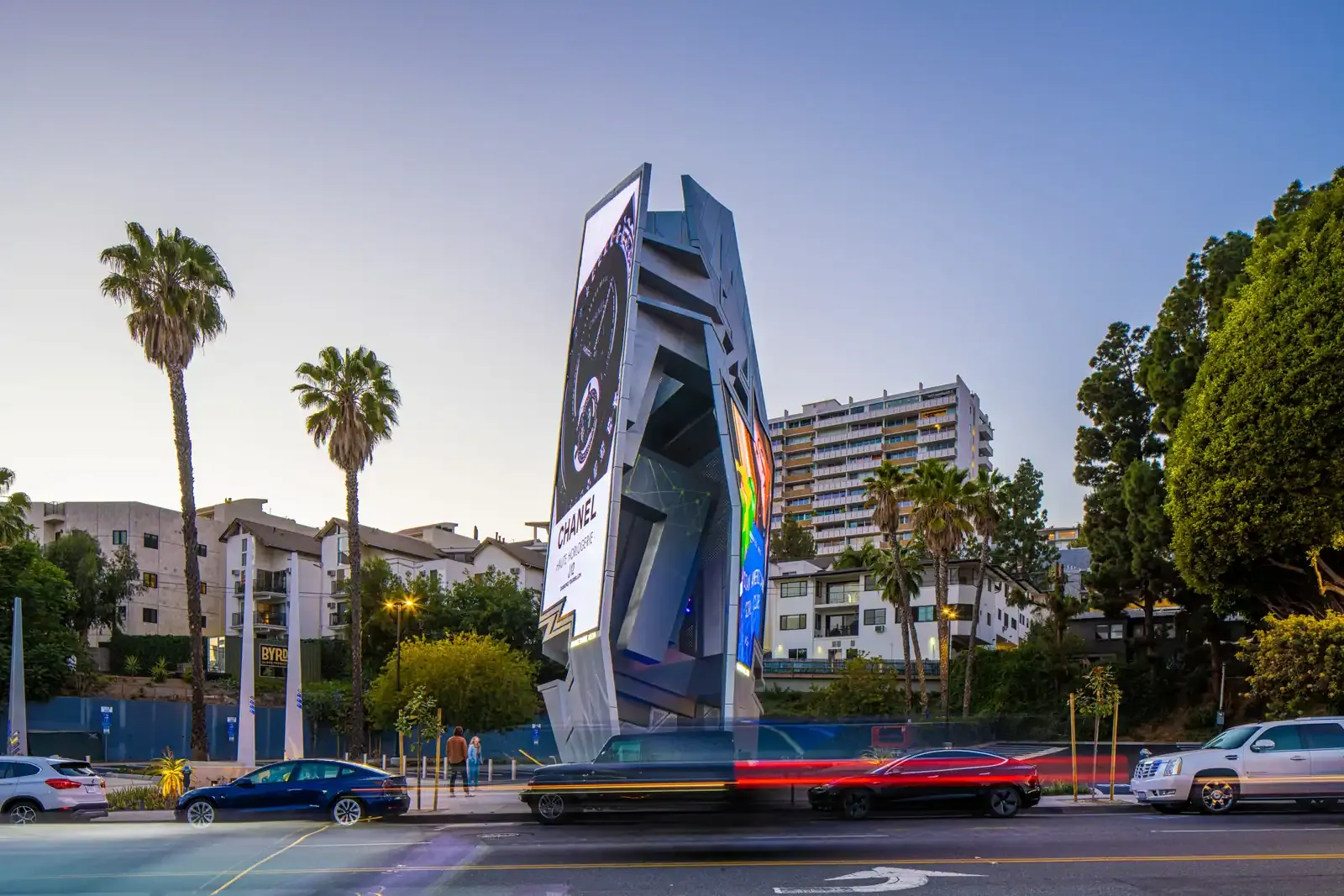 The Sunset Spectacular, a 67-foot stainless steel media tower by Orange Barrel Media, on the Sunset Strip at twilight