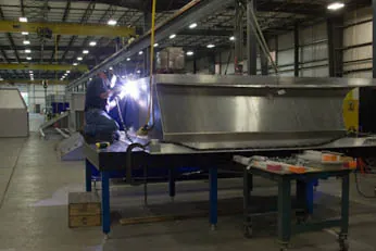 Northern Manufacturing fabricator welding a stainless steel assembly on the shop floor