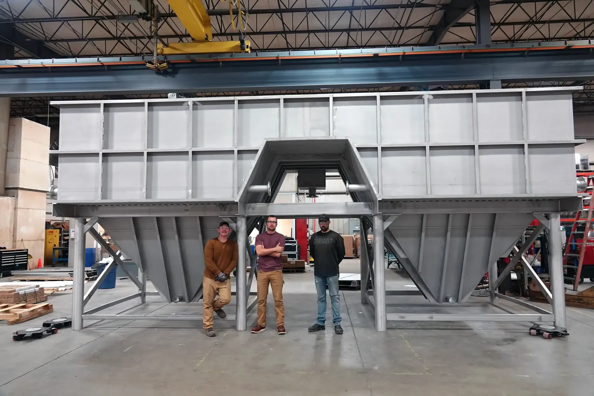 Three Northern Manufacturing craftsmen in front of a large custom stainless steel fabrication