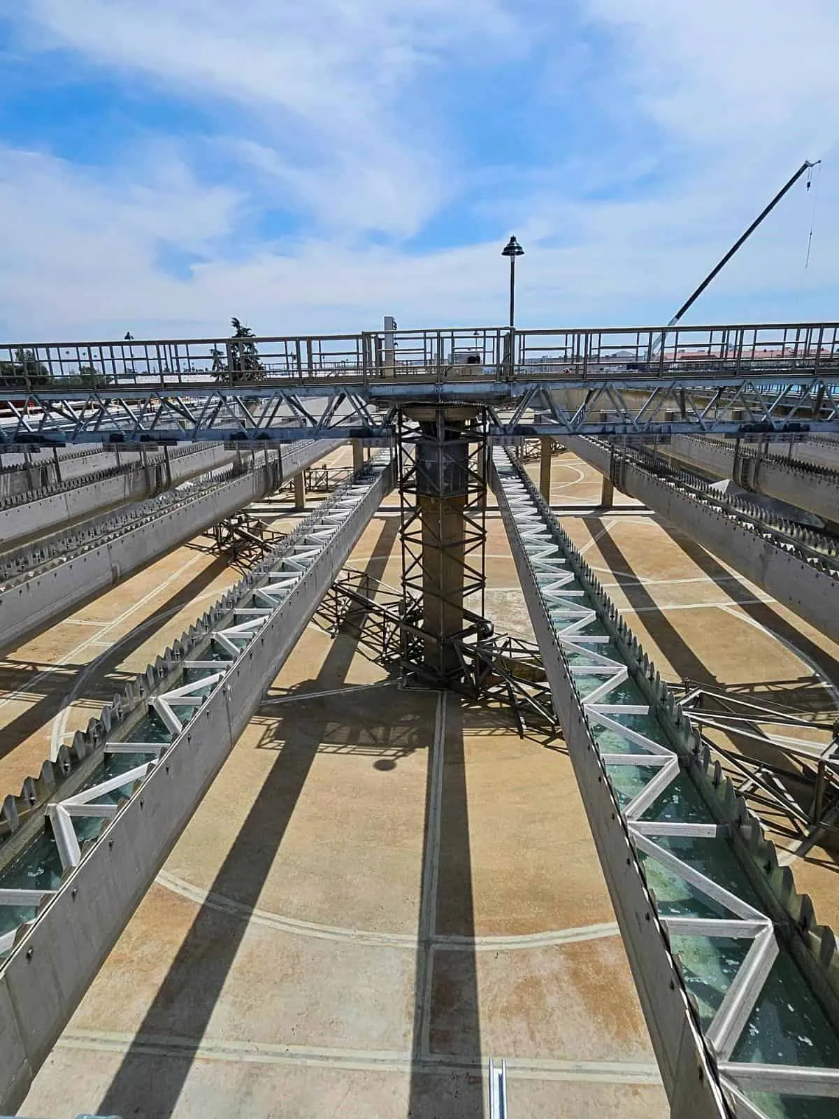 Stainless steel collector troughs and weirs spanning a clarifier basin at a wastewater treatment plant